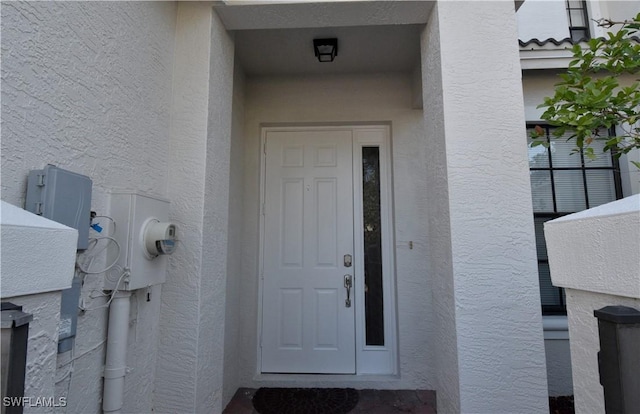 entrance to property featuring stucco siding