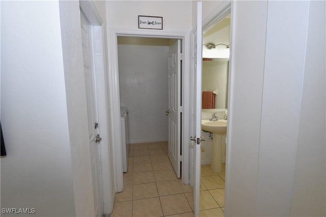 hallway featuring washer / clothes dryer and light tile patterned floors