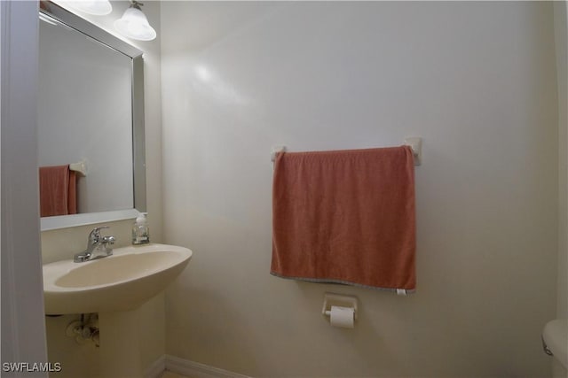 bathroom featuring baseboards and toilet
