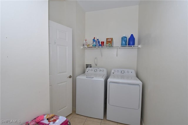 washroom with washing machine and dryer, laundry area, and light tile patterned floors