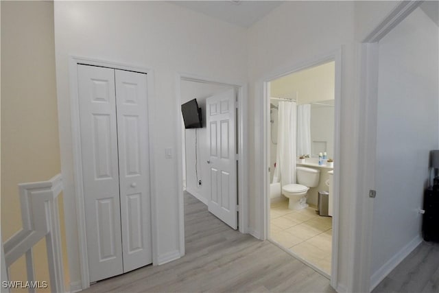hallway with baseboards and light wood-style flooring