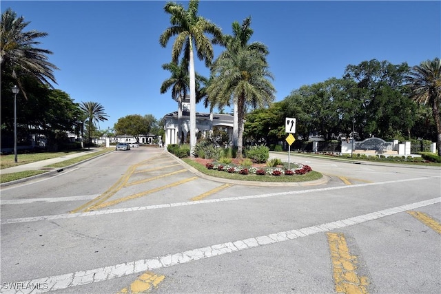 view of road featuring curbs, street lighting, traffic signs, and sidewalks