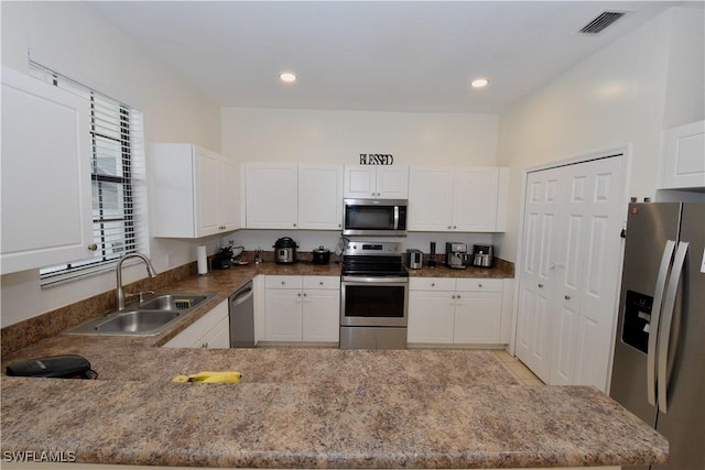 kitchen featuring white cabinets, visible vents, stainless steel appliances, and a sink
