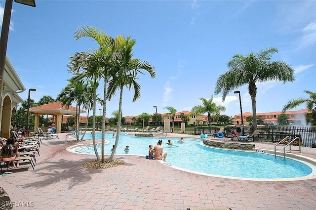 community pool featuring fence, a gazebo, and a patio