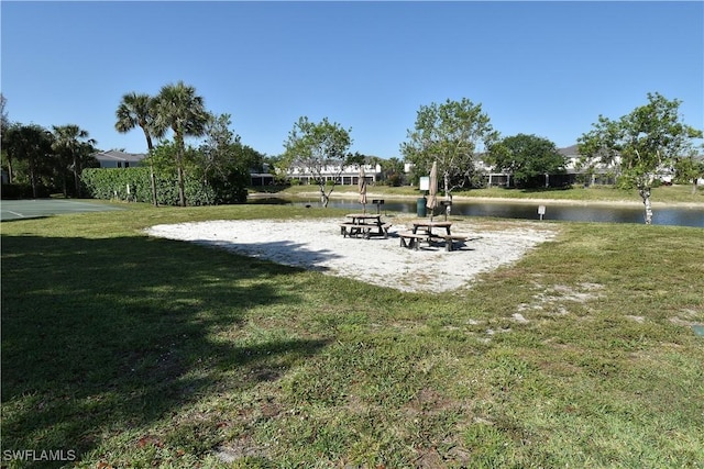 surrounding community featuring a lawn and a water view
