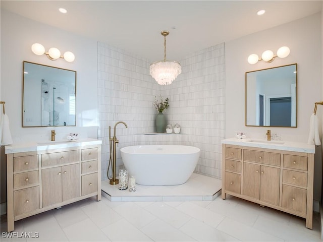 1072 S Seas Plantation Rd, Captiva, FL 33924 - full bathroom with tile walls, two vanities, a freestanding tub, a stall shower, and a chandelier