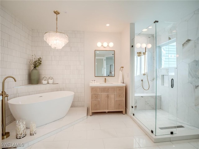1072 S Seas Plantation Rd, Captiva, FL 33924 - bathroom featuring a marble finish shower, a freestanding bath, vanity, tile walls, and a chandelier