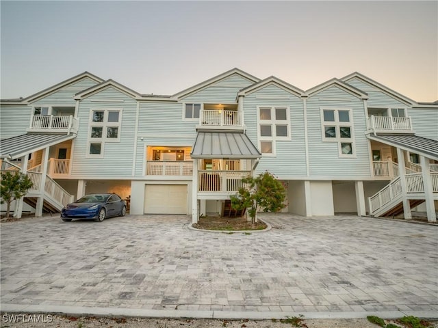 1072 S Seas Plantation Rd, Captiva, FL 33924 - view of front of property featuring decorative driveway, an attached garage, stairs, a standing seam roof, and a metal roof