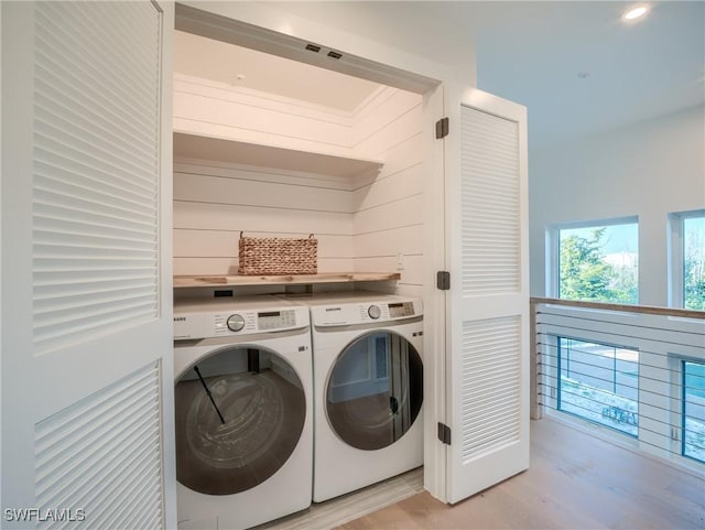 1072 S Seas Plantation Rd, Captiva, FL 33924 - washroom with washing machine and clothes dryer and light wood finished floors