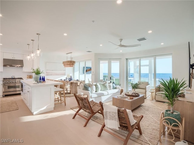 1072 S Seas Plantation Rd, Captiva, FL 33924 - living room featuring recessed lighting, ceiling fan, a water view, and light wood-style flooring