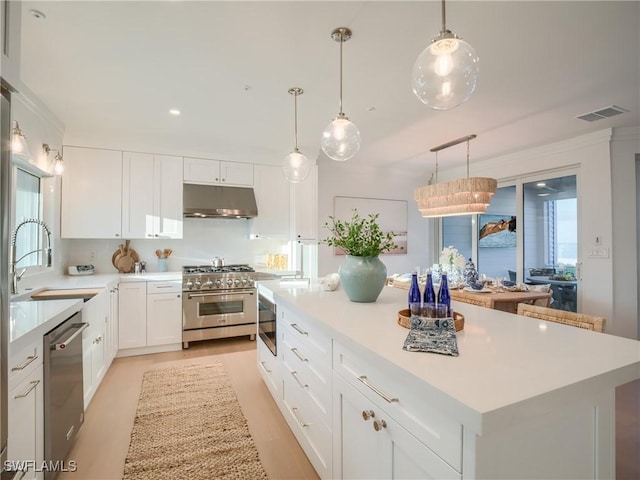 1072 S Seas Plantation Rd, Captiva, FL 33924 - kitchen featuring appliances with stainless steel finishes, under cabinet range hood, light countertops, white cabinetry, and recessed lighting
