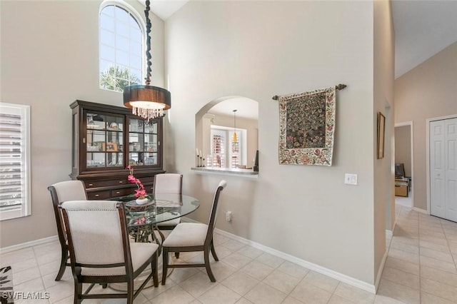20131 Seagrove St Unit 408, Estero, FL 33928 - dining area with high vaulted ceiling, baseboards, light tile patterned floors, and arched walkways