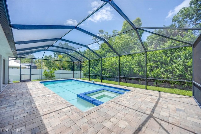 view of pool with glass enclosure, a pool with connected hot tub, and a patio
