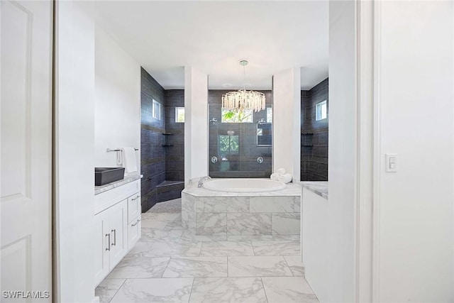 bathroom featuring a garden tub, marble finish floor, and a healthy amount of sunlight