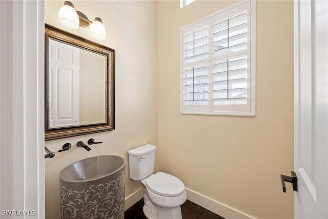 bathroom with toilet and baseboards