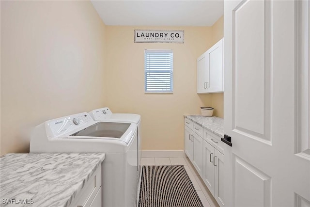 laundry room with baseboards, light tile patterned flooring, washer and dryer, and cabinet space