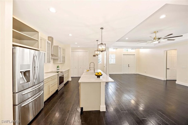 kitchen featuring stainless steel fridge, electric range oven, light countertops, wall chimney exhaust hood, and dark wood-type flooring