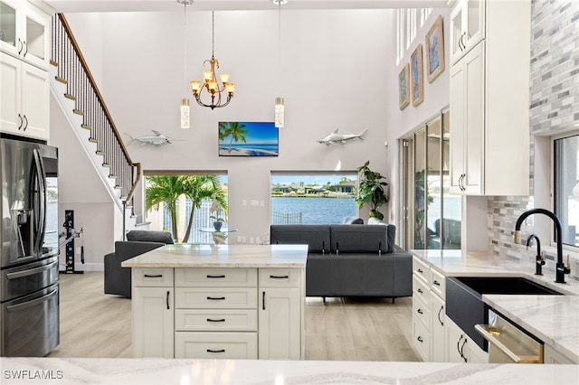 603 SW 53rd Ter, Cape Coral, FL 33914 - kitchen with light wood-style floors, appliances with stainless steel finishes, open floor plan, and a sink