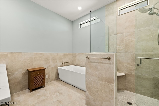 603 SW 53rd Ter, Cape Coral, FL 33914 - bathroom with a shower stall, tile walls, and a freestanding bath