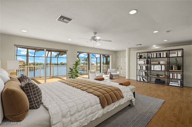 603 SW 53rd Ter, Cape Coral, FL 33914 - bedroom with recessed lighting, visible vents, a water view, wood finished floors, and access to exterior