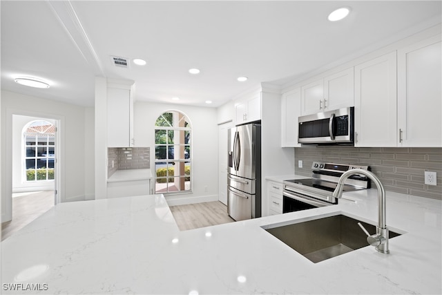 505 Mardel Dr Unit 106, Naples, FL 34104 - kitchen with appliances with stainless steel finishes, light stone counters, backsplash, a sink, and recessed lighting