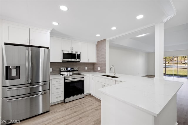 505 Mardel Dr Unit 106, Naples, FL 34104 - kitchen featuring stainless steel appliances, a sink, a peninsula, light wood-type flooring, and recessed lighting
