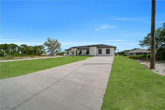 4646 Leonard Blvd S, Lehigh Acres, FL 33973 - view of front of house with concrete driveway, a front lawn, and stucco siding