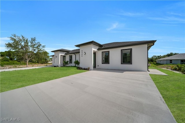 4646 Leonard Blvd S, Lehigh Acres, FL 33973 - view of front facade with a front yard, stucco siding, and driveway