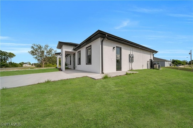 4646 Leonard Blvd S, Lehigh Acres, FL 33973 - rear view of house with stucco siding, a lawn, and driveway
