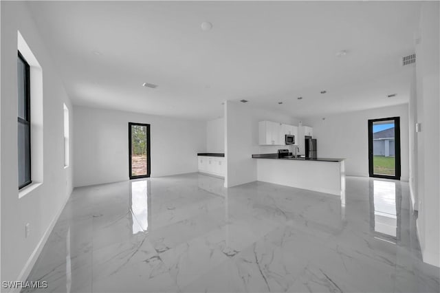 4646 Leonard Blvd S, Lehigh Acres, FL 33973 - unfurnished living room with light marble finish floors, a sink, and baseboards