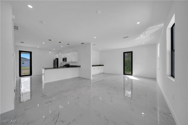 4646 Leonard Blvd S, Lehigh Acres, FL 33973 - unfurnished living room with healthy amount of natural light, recessed lighting, light marble finish floors, a sink, and baseboards