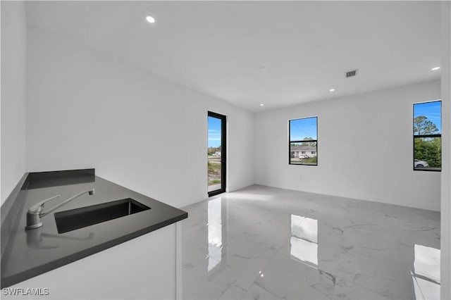 4646 Leonard Blvd S, Lehigh Acres, FL 33973 - empty room with a sink, plenty of natural light, marble tiled floors, and recessed lighting