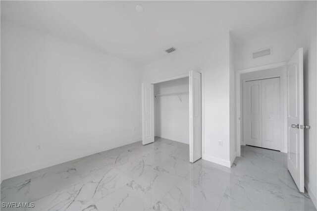 4646 Leonard Blvd S, Lehigh Acres, FL 33973 - unfurnished bedroom featuring light marble finish flooring and a closet