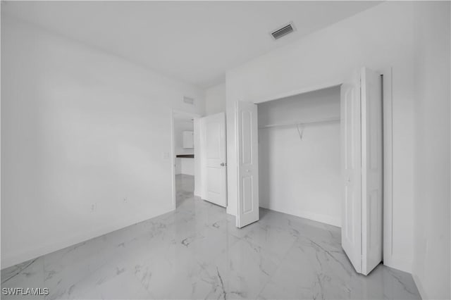 4646 Leonard Blvd S, Lehigh Acres, FL 33973 - unfurnished bedroom with marble look tile flooring, baseboards, and a closet