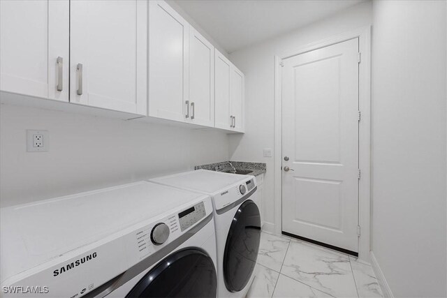 2948 2nd Ave NE, Naples, FL 34120 - washroom featuring independent washer and dryer, cabinet space, light marble finish flooring, and baseboards