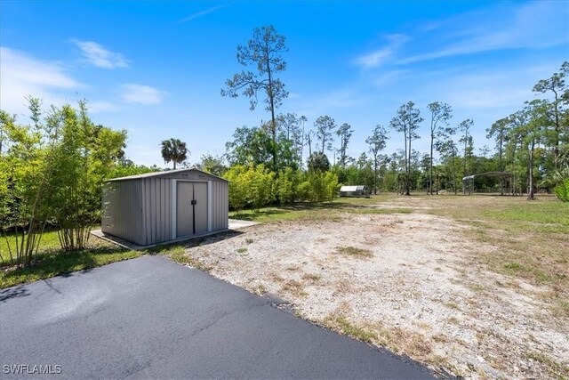 2948 2nd Ave NE, Naples, FL 34120 - view of yard with a storage unit and an outbuilding