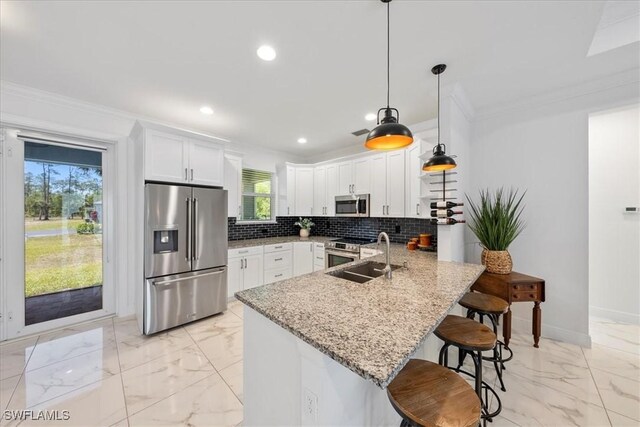 2948 2nd Ave NE, Naples, FL 34120 - kitchen featuring appliances with stainless steel finishes, a peninsula, light marble finish floors, a kitchen bar, and ornamental molding