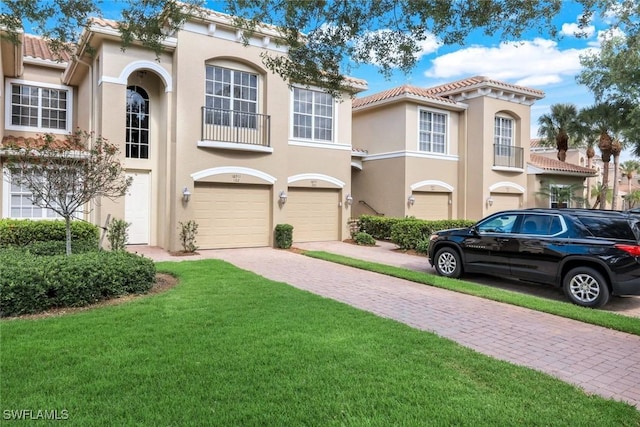 18911 Bay Woods Lake Dr Unit 102, Fort Myers, FL 33908 - view of front facade with driveway, a tile roof, stucco siding, an attached garage, and a front yard