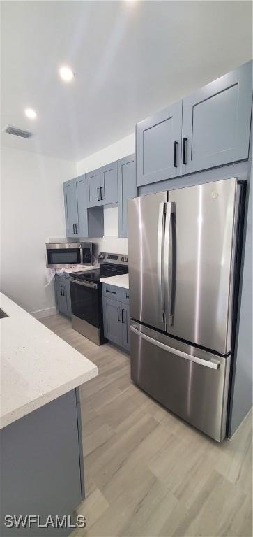3501 70th St W, Lehigh Acres, FL 33971 - kitchen featuring visible vents, recessed lighting, light stone counters, light wood finished floors, and stainless steel appliances
