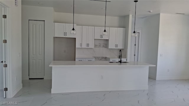 3501 70th St W, Lehigh Acres, FL 33971 - kitchen with baseboards, a sink, marble finish floor, and white cabinets