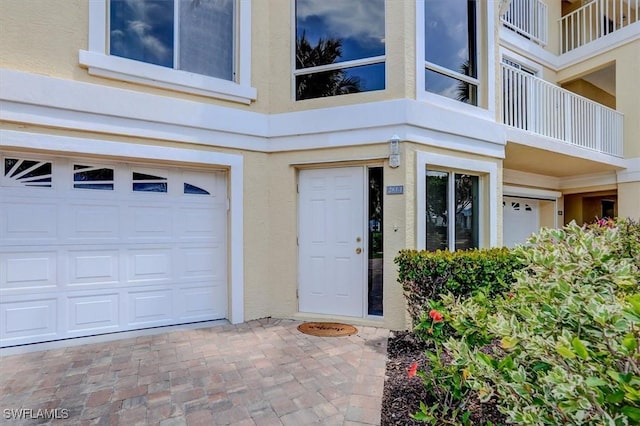 281 Lenell Rd Unit 1 7-A, Fort Myers Beach, FL 33931 - view of exterior entry with an attached garage and stucco siding