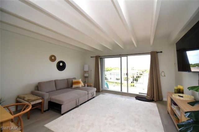living area featuring light wood-style floors, beamed ceiling, and plenty of natural light