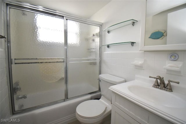 full bath featuring tile walls, vanity, shower / bath combination with glass door, and toilet