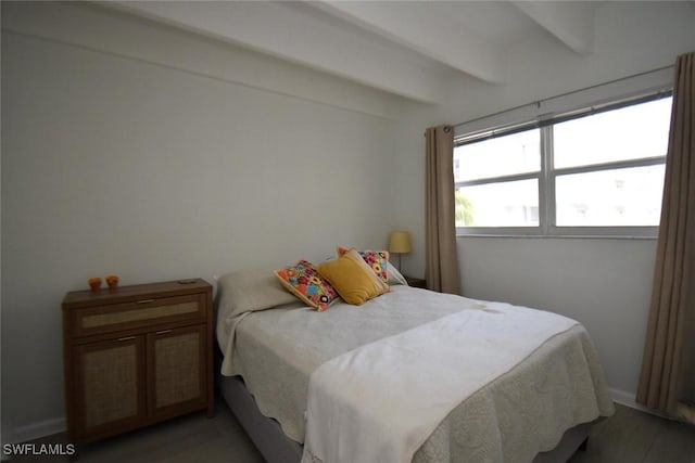 bedroom with beamed ceiling and light wood-style flooring
