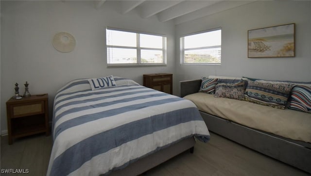 bedroom featuring beamed ceiling and wood finished floors