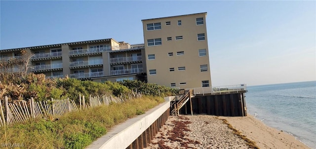 view of property with a beach view and a water view