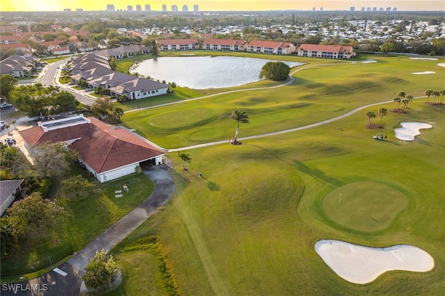 birds eye view of property with view of golf course, a residential view, and a water view