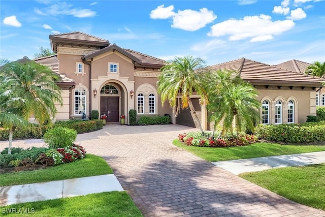 8993 Crooked Stick Ct, Naples, FL 34113 - mediterranean / spanish home with an attached garage, stucco siding, a tile roof, and decorative driveway