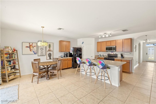 618 SW 18th St, Cape Coral, FL 33991 - kitchen featuring arched walkways, light tile patterned floors, light countertops, black appliances, and visible vents