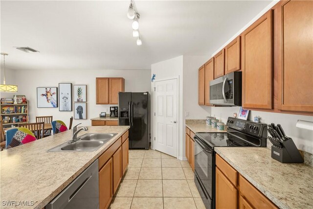 618 SW 18th St, Cape Coral, FL 33991 - kitchen featuring a sink, light tile patterned floors, black appliances, light countertops, and hanging light fixtures